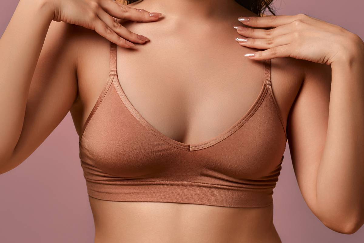 Close up of woman's body, pink background.