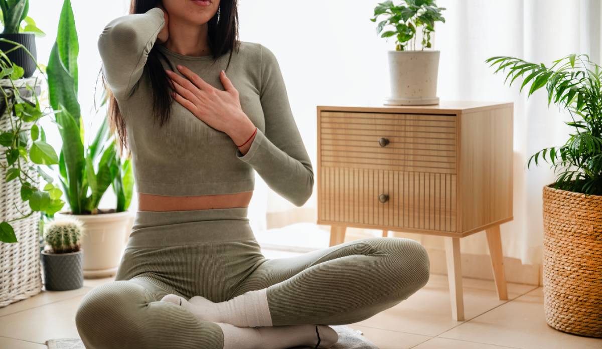 Woman doing yoga breathing exercises at home